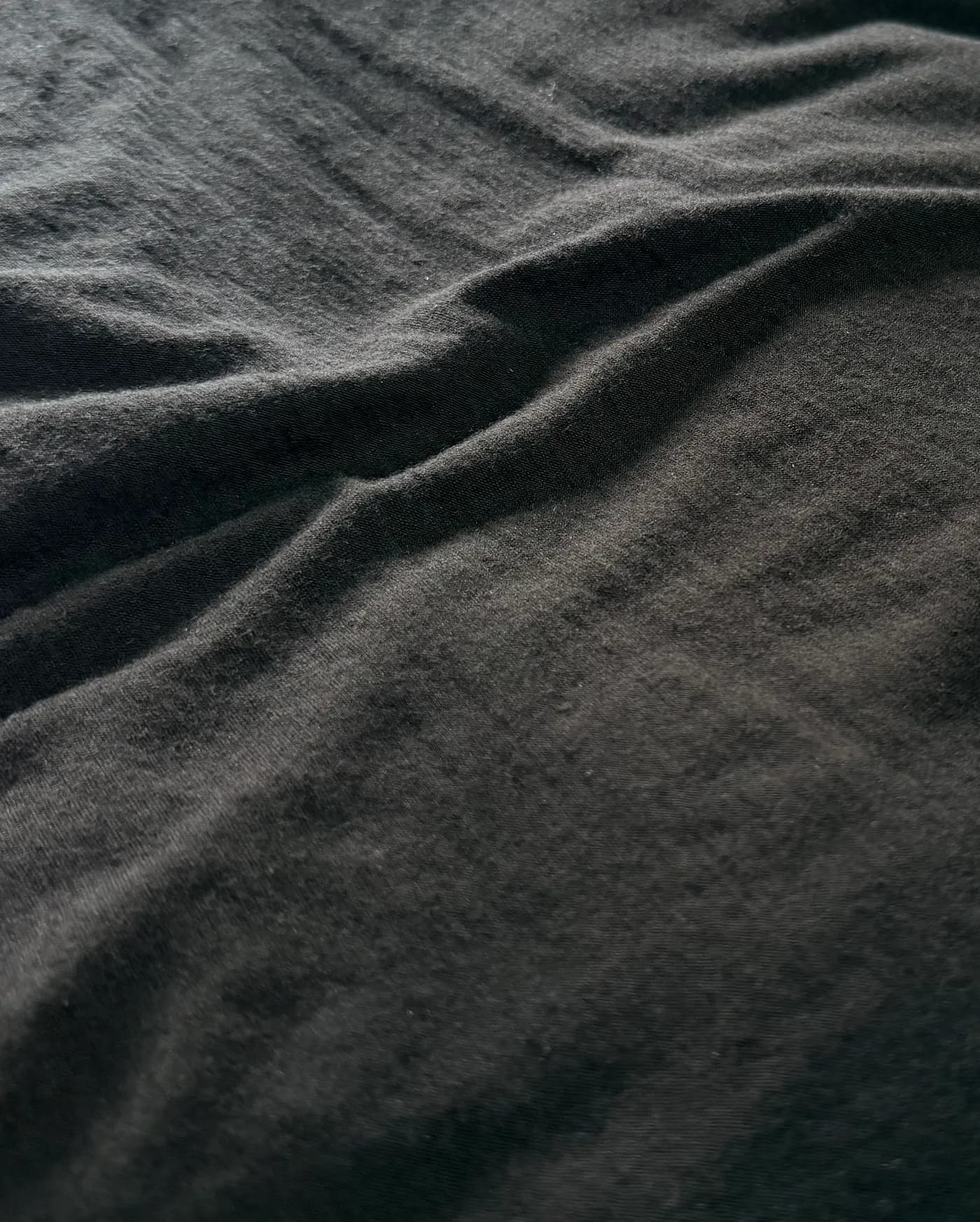 Real sample of our grey wool-nylon core-spun single jersey, shown in natural folds.