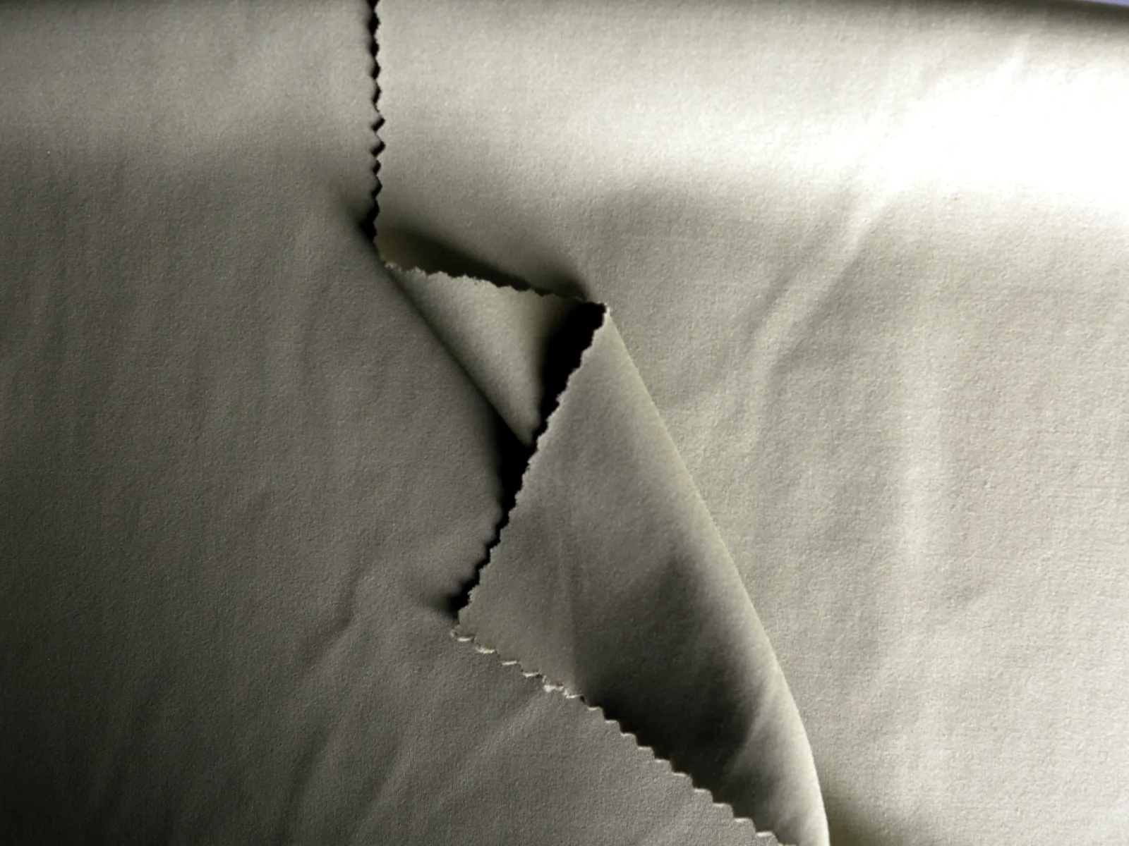 Grey nylon-spandex double-brushed knit with folded fabric, visible cut edges and a fine brushed surface.