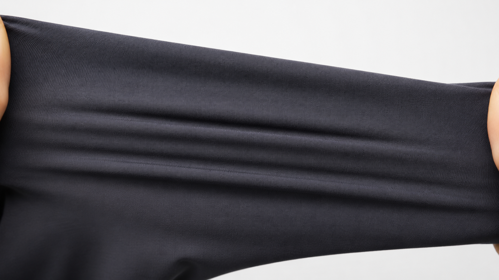 Dark charcoal stretch performance fabric being pulled to show elasticity